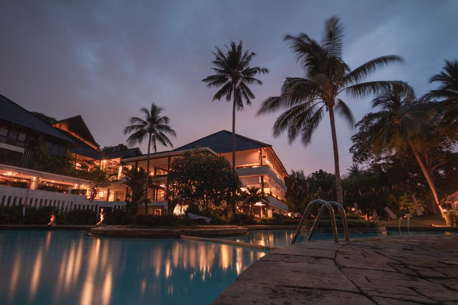 Illustrative coastal property with a pool and palm trees